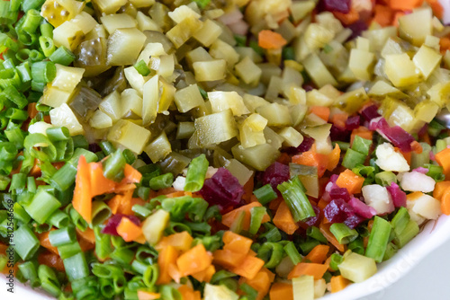 A tasty salad named Vinaigrette - a traditional Ukrainian and Russian  vegetable salad.  Vegetarian dish. Vegan food with green onion  boiled potatoes  carrot  beet. Salad background