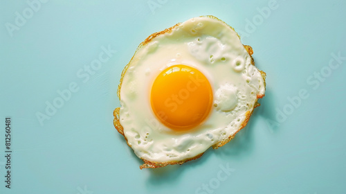 A fried egg with a yellow yolk sits on a blue background