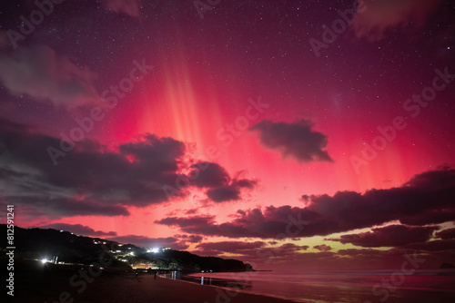 Aurora Australis at Muriwai Beach on 11 May, 2024. Crowd of people watching on the beach. Auckland.