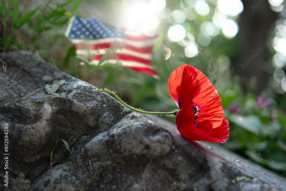 Close-up of a red poppy leaning against a granite tombstone with a softly waving American flag in the background symbolizing remembrance. Close-up of a red poppy leaning against a granite tombstone with a softly waving American flag in the background symbolizing remembrance.