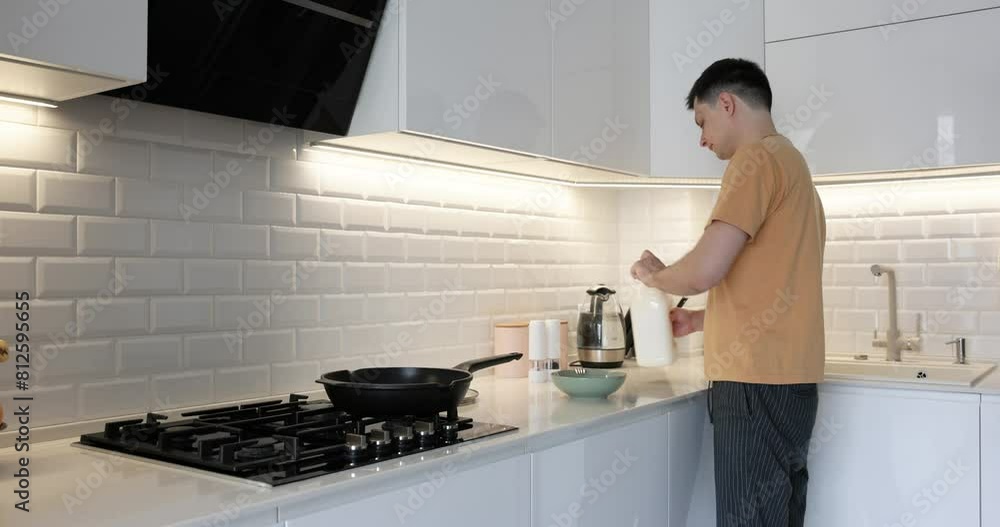 Caucasian man preparing omelet for breakfast in modern interior kitchen Caucasian man preparing omelet for breakfast in modern interior kitchen
