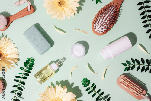 Beauty and spa accessories, cosmetics background with organic ingredients, skincare products and yellow gerbera flowers on green background with sharp shadows. Top view, flat lay