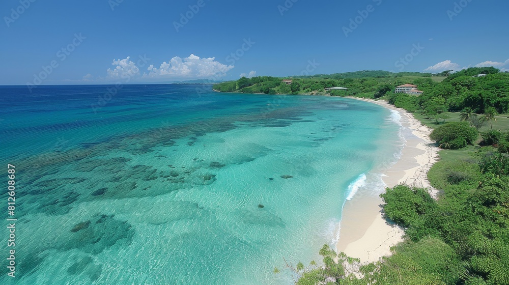 Aerial view of a peaceful beach with clear waters, white sand, green foliage, and a secluded, calm ambiance