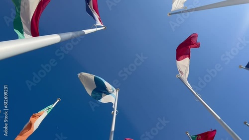 Flags of many countries waveing in the wind with blue sky from below