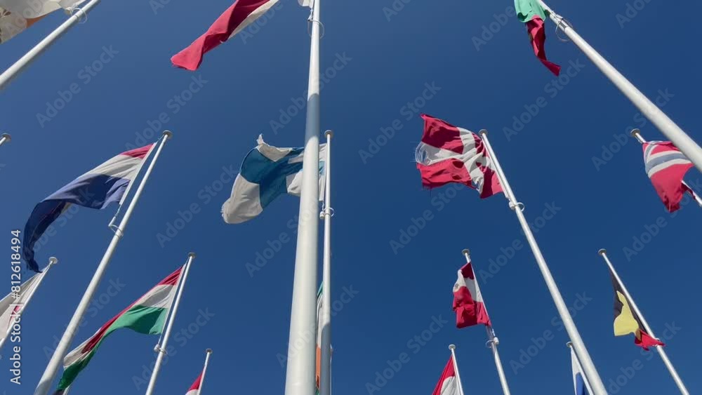 Flags of many countries waveing in the wind with blue sky from below