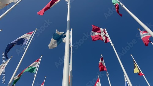 Flags of many countries waveing in the wind with blue sky from below