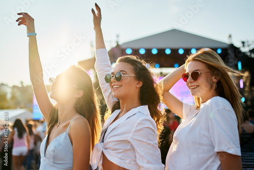 Photography Group of joyful young women dance at sunny beach music festival