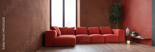 Red modular corner sofa against blank brown stucco wall with copy space. Loft interior design of modern living room design