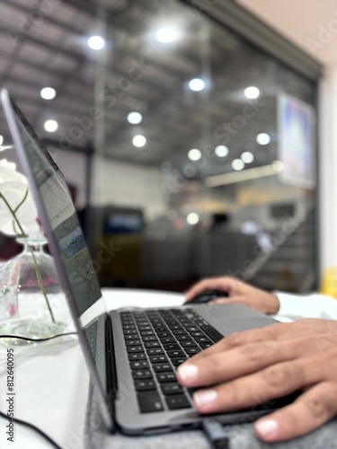 Hand working on a laptop with blurred background