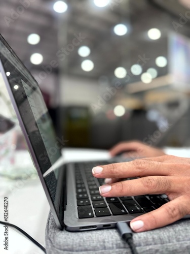 Fingers of a man working on a laptop with blurred background