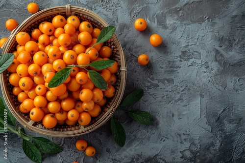 A full basket of sea buckthorn berries with green leafy accents on a dark moody background photo