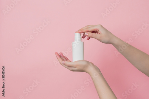 Hand holds white cream bottle with pump. Concept of beauty. Daily beauty product