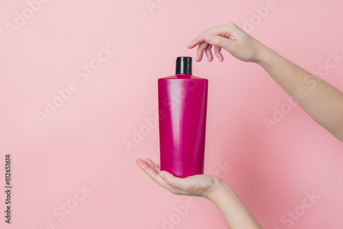 Cosmetic unbranded bottle for shampoo, mask, lotion in hands. Concept of beauty. Product cosmetic advertising