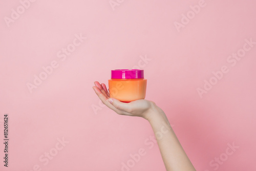 Hand holds cosmetic bottle for hair mask, balm or body lotion. Daily beauty product. Product cosmetic advertising