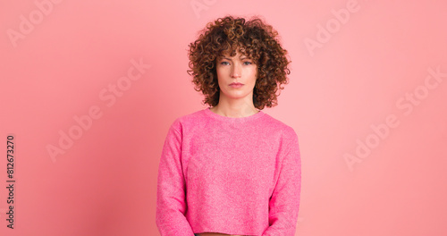 Bild auf Leinwand Standing charming young woman with curly hair in pink background