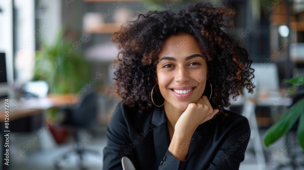 A woman sitting at her desk in the office. Happy business woman sitting in the office A woman sitting at her desk in the office. Happy business woman sitting in the office