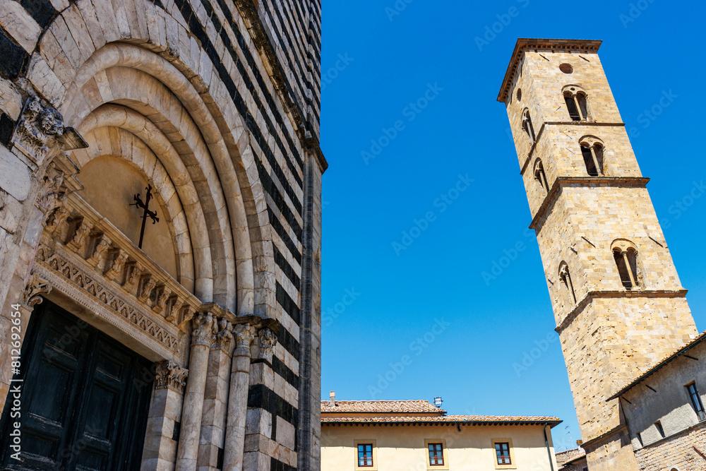 Facade of the Baptistery of Saint John and the clock tower of the cathedral in Volterra, Tuscany, Italy, Europe Facade of the Baptistery of Saint John and the clock tower of the cathedral in Volterra, Tuscany, Italy, Europe