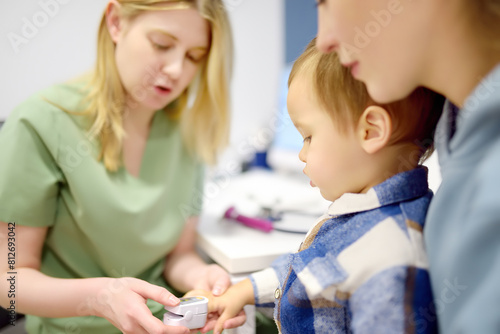 Bilde på lerret A cute toddler boy is at an appointment with a caring pediatrician