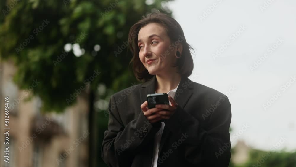 Beautiful woman walking down hold smartphone scrolling social media texting browsing online at green urban city Pretty female relax enjoying great day after study or work at street park outdoors	