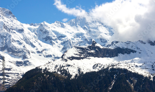 Alpine mountains in Switzerland. Snowy peak against the blue sky. Tourist resort. Nature in Europe