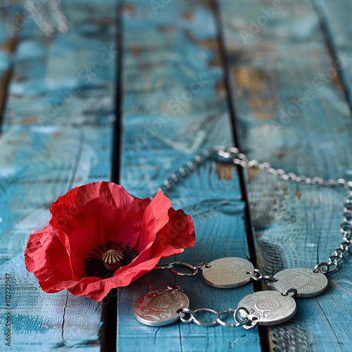 Vintage blue wooden table adorned with a red poppy and soldier's tags  Memorial Day. photo