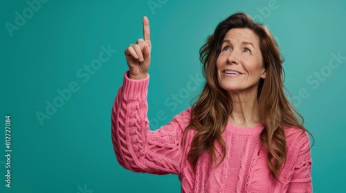 Woman in Pink Sweater Pointing Up photo