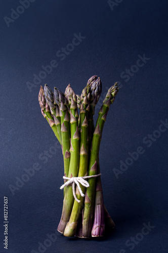 Bundle of asparagus on black background minimalist aesthetic copy space