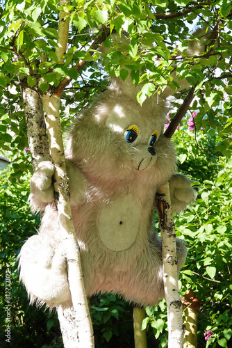 A big plush hare climbed a tree photo