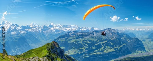 Paraglider soaring over stunning Alpine landscape with panoramic views of snow-capped mountains and lush valleys. Extreme sports and adventure travel concept .