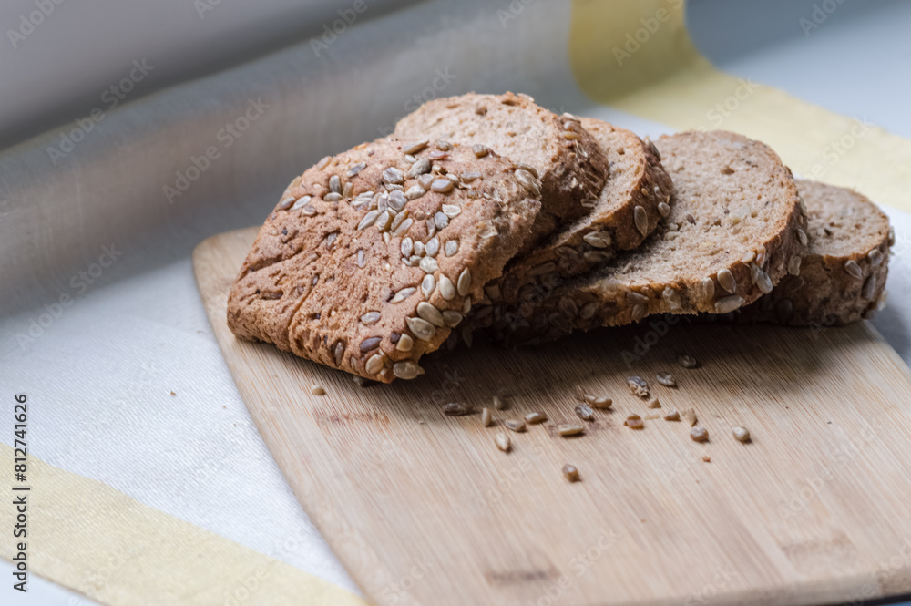 Sliced wholemeal bread with sunflower seeds on wooden board