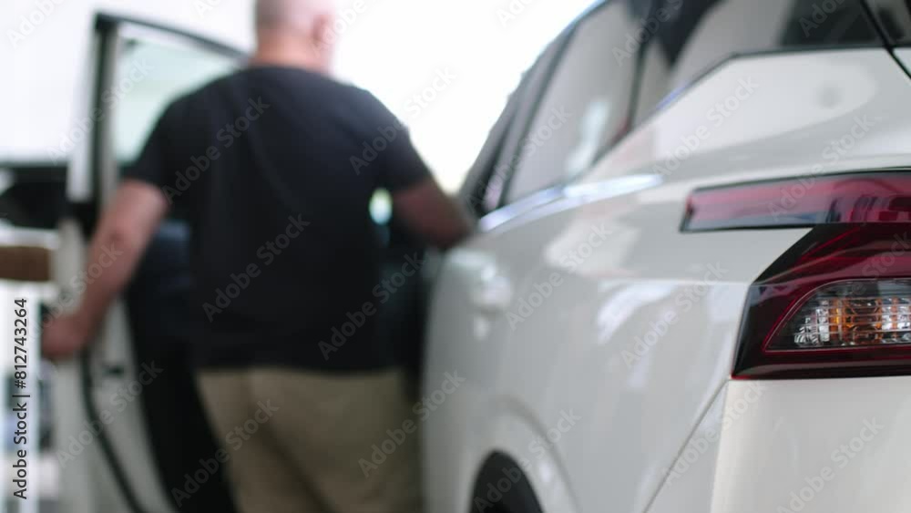 The buyer, a client of a modern car dealership, chooses a car. A dealer talks about a new model of a modern electric car. The concept of test drive, buying an electric car or renting it. The buyer, a client of a modern car dealership, chooses a car. A dealer talks about a new model of a modern electric car. The concept of test drive, buying an electric car or renting it.