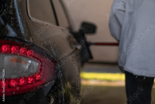 man washes his car at the car wash