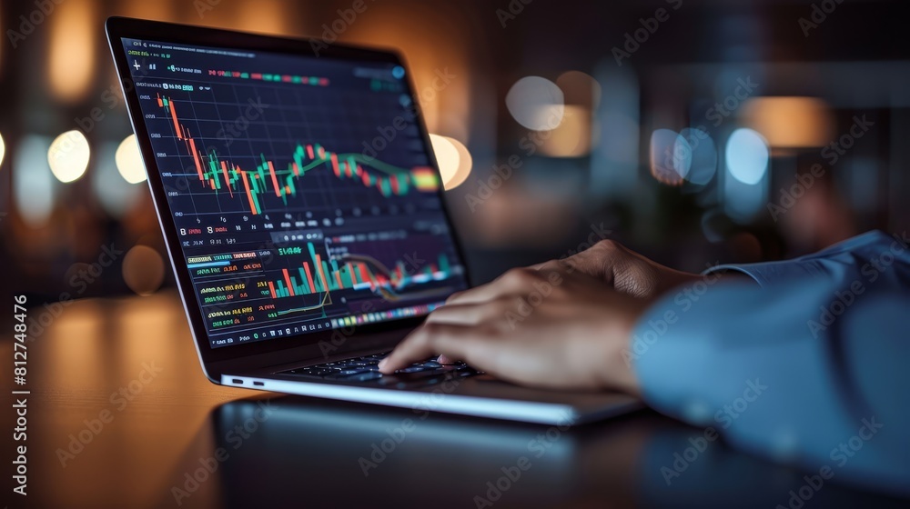 A business professional is using their laptop to explore stock market trends on an online platform A business professional is using their laptop to explore stock market trends on an online platform
