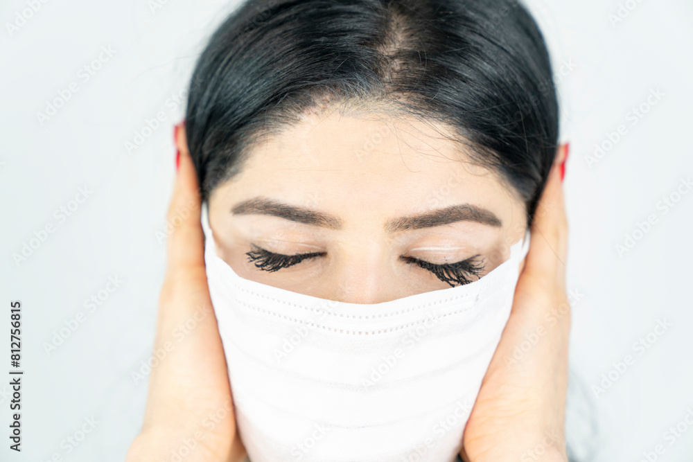 Young woman with surgical mask on face against SARS-CoV-2. COVID-19 Pandemic Coronavirus Young girl in white room wearing face mask Young woman with surgical mask on face against SARS-CoV-2. COVID-19 Pandemic Coronavirus Young girl in white room wearing face mask