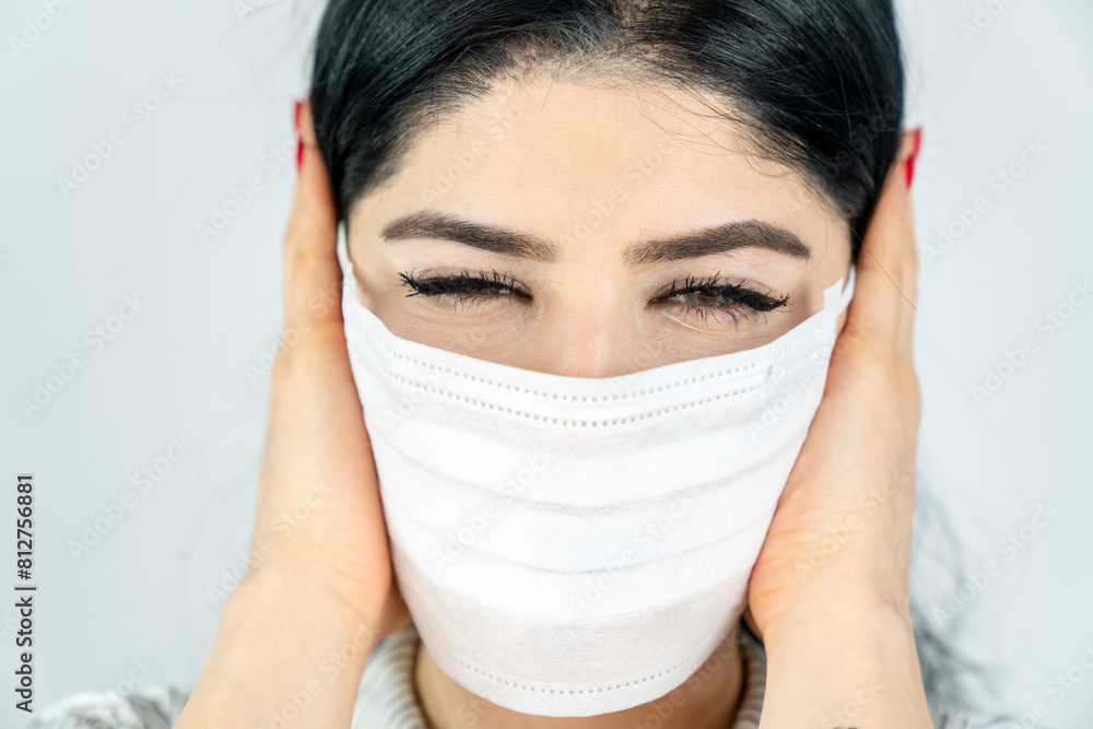 Young woman with surgical mask on face against SARS-CoV-2. COVID-19 Pandemic Coronavirus Young girl in white room wearing face mask Young woman with surgical mask on face against SARS-CoV-2. COVID-19 Pandemic Coronavirus Young girl in white room wearing face mask