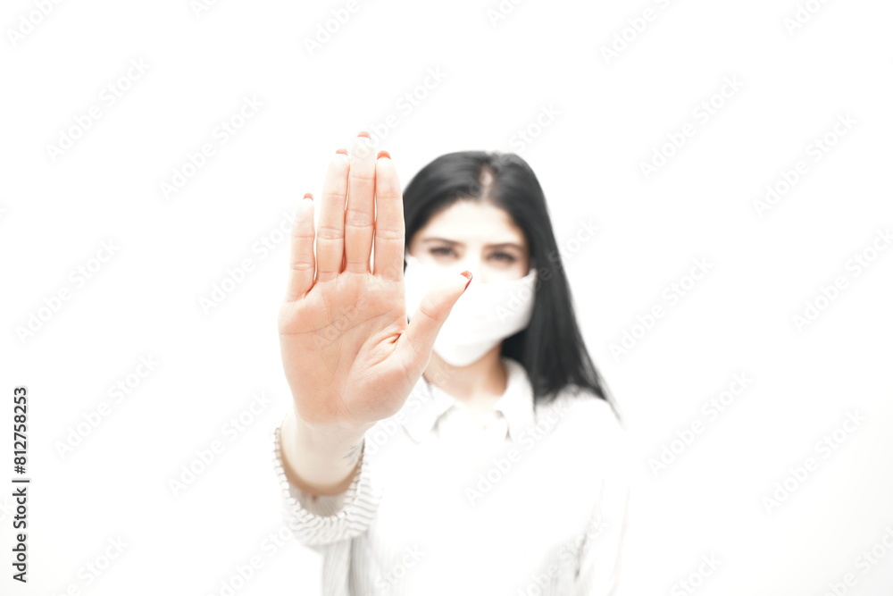 Young woman with surgical mask on face against SARS-CoV-2. woman wearing health mask showing stop sign Young woman with surgical mask on face against SARS-CoV-2. woman wearing health mask showing stop sign