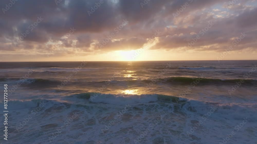 Drone video of waves at sunset with sunlight reflecting off ocean and clouds Drone video of waves at sunset with sunlight reflecting off ocean and clouds