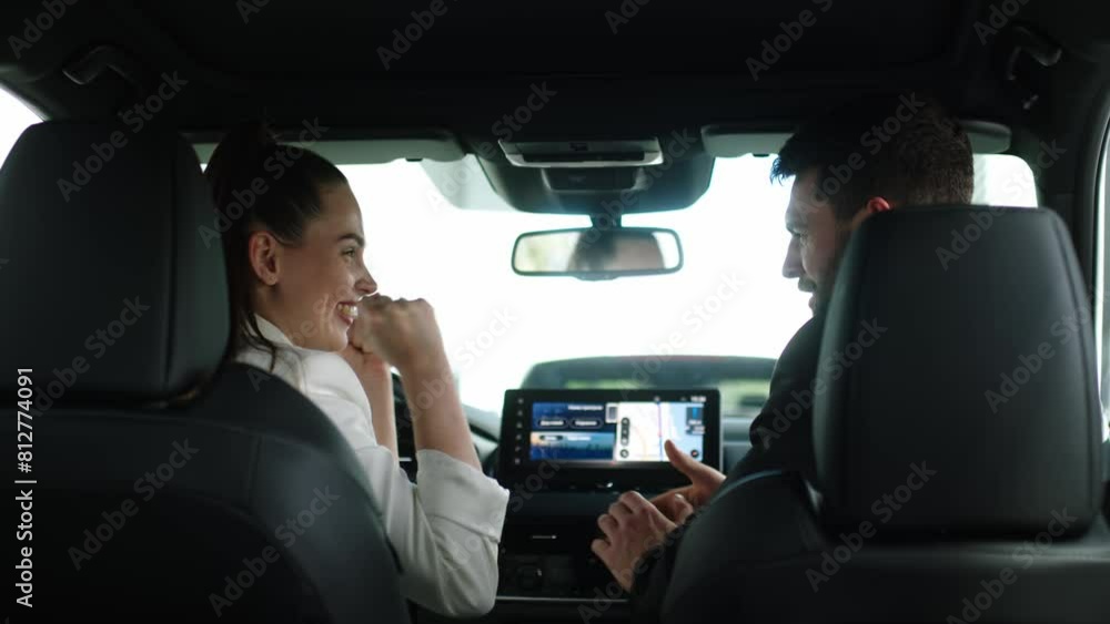 A young couple in love buys a new car at a car dealership. A young attractive man with a beard and a young beautiful woman in a modern car showroom. A young couple in love buys a new car at a car dealership. A young attractive man with a beard and a young beautiful woman in a modern car showroom.
