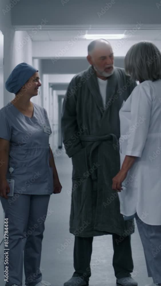 Nurse in uniform walks hospital corridor with aged man and comes to lift door. Female healthcare specialist meets elderly patient in medical center hallway. Medical personnel work in modern clinic. Nurse in uniform walks hospital corridor with aged man and comes to lift door. Female healthcare specialist meets elderly patient in medical center hallway. Medical personnel work in modern clinic.