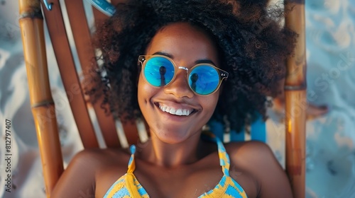 Portrait of happy young black woman relaxing on wooden deck chair at tropical beach while looking at camera wearing spectacles Smiling african american girl with fashion sunglasses enj : Generative AI