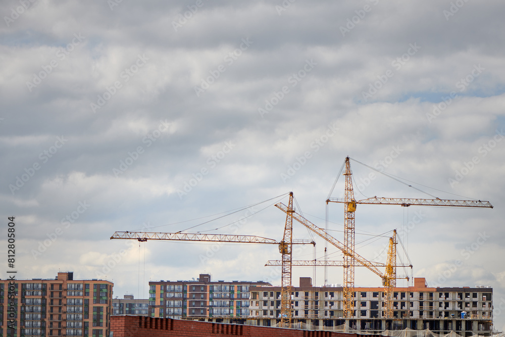 Group of tower crane on construction site. Tall buildings under construction. Real estate construction. Concept of urban development and architecture. Group of tower crane on construction site. Tall buildings under construction. Real estate construction. Concept of urban development and architecture.