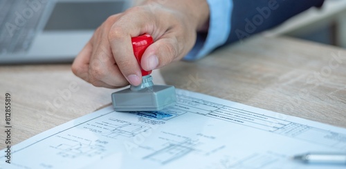 Fotografía A person stamping a document with a rubber stamp.