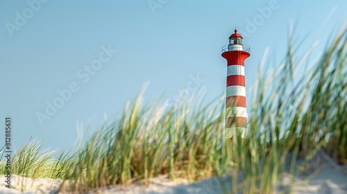 Red and white striped tall building of lighthouse against blue clear sky Sand ground with green grass in foreground Summer vacation holiday at sea concept : Generative AI