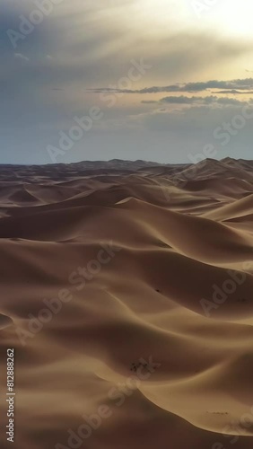 Aerial view of the sand dunes Hongoryn Els in Gobi Desert at sunset, Mongolia. Vertical video photo