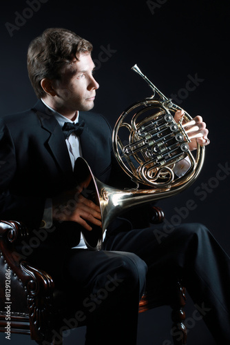 French horn player. Hornist playing brass instrument photo