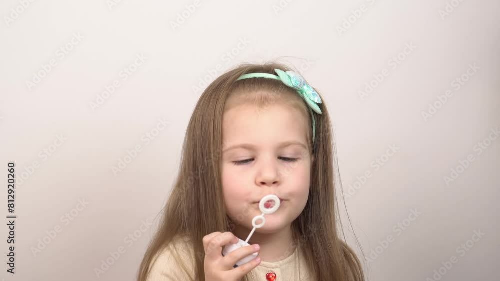 Little girl playing in making balloons. Portrait of a girl playing with soap bubbles and looking at the camera at studio on a white background. Little girl playing in making balloons. Portrait of a girl playing with soap bubbles and looking at the camera at studio on a white background.