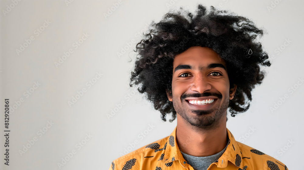 Joven afroamericano sonriente con camisa estampada en fondo neutro Joven afroamericano sonriente con camisa estampada en fondo neutro