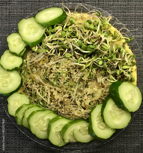 Konstfotografi Top view of omelet with green onion, sprouted mung beans and cucumber in plate at black table
