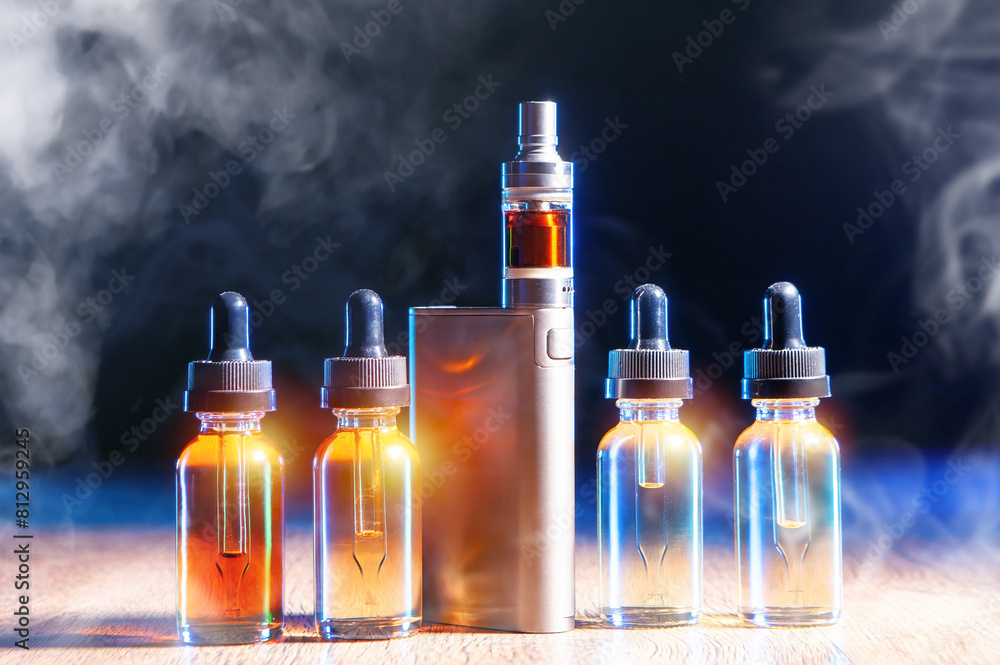 Vape device. Oil for electronic cigarettes. Vaping liquid on table. Vaper kit in smoke. Vaping oil bottles. Tobacco-less smoking system. Vape pen on black background. E-cig with water for refilling Vape device. Oil for electronic cigarettes. Vaping liquid on table. Vaper kit in smoke. Vaping oil bottles. Tobacco-less smoking system. Vape pen on black background. E-cig with water for refilling
