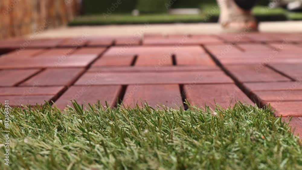 Installing brown wooden tiles on a balcony terrace, creating a floor. A person lays tiles on the floor. Time-lapse video. Installing brown wooden tiles on a balcony terrace, creating a floor. A person lays tiles on the floor. Time-lapse video.